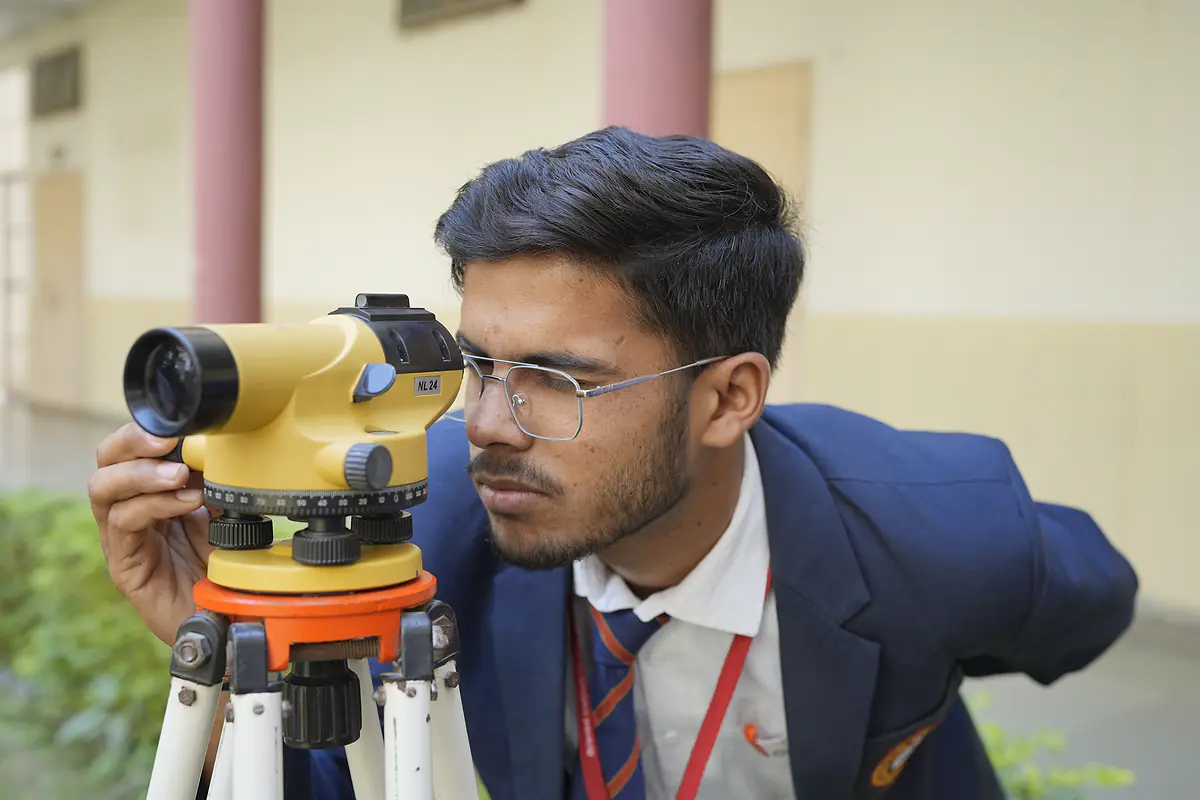 A student looks through a surveying level