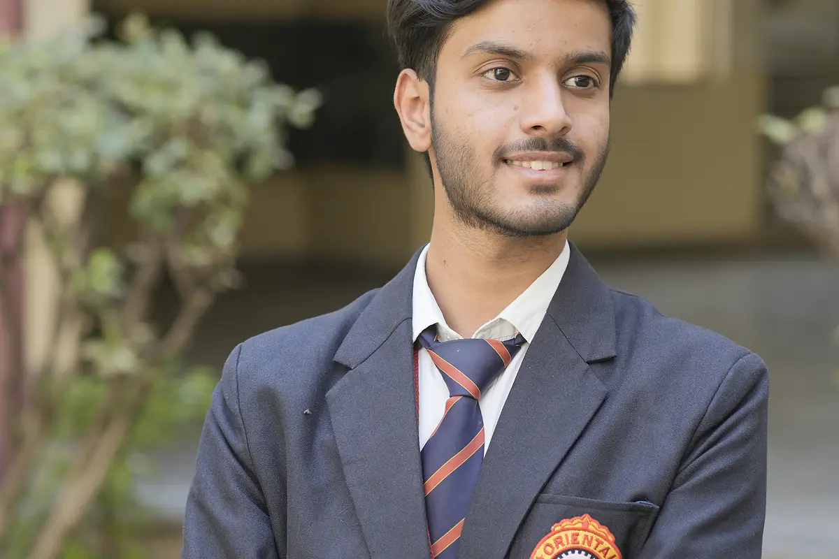 A student in a blazer, smiling