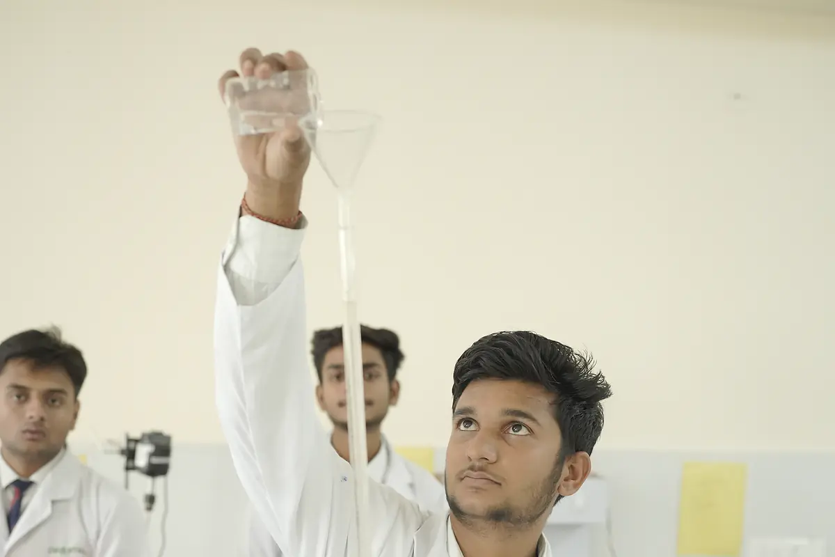 A pharmacy student fills a burette in the lab