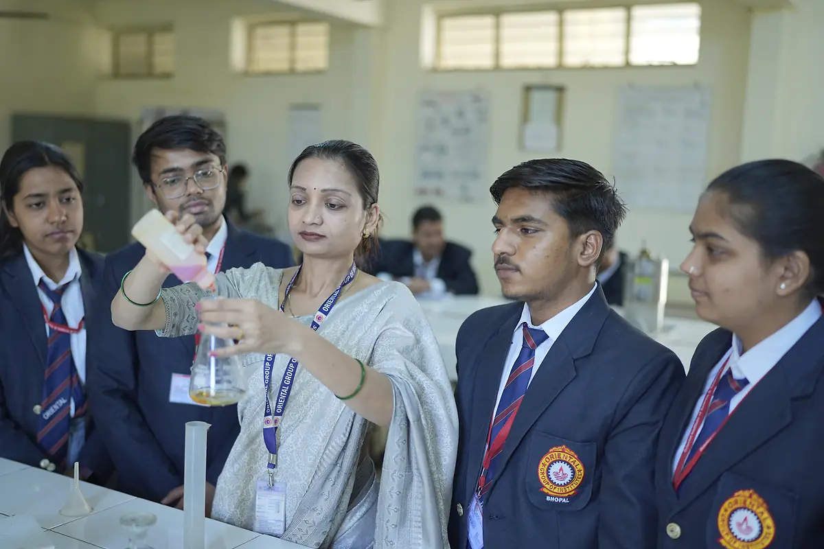 A faculty member demonstrates a titration to students in the lab