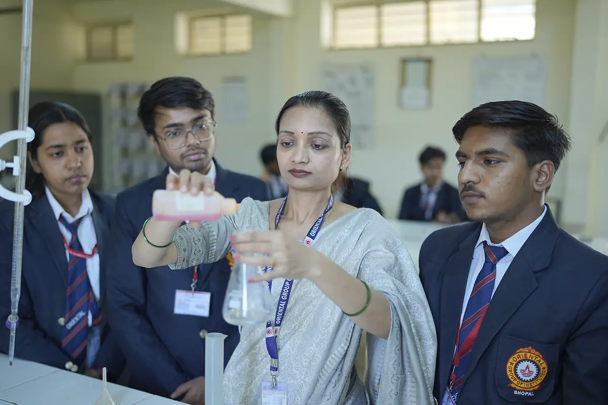 Students watch a titration at a lab bench